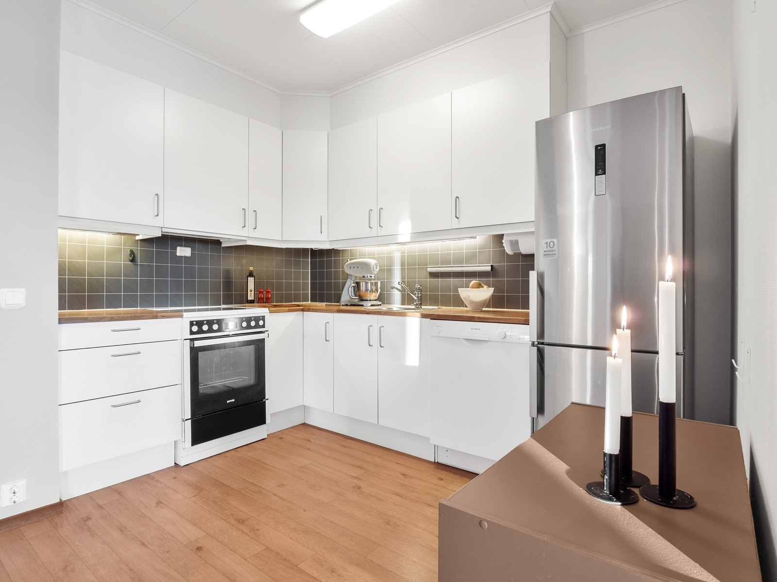 Kjøkkenet har godt med oppbevarings- og benkeplass Galleribilde