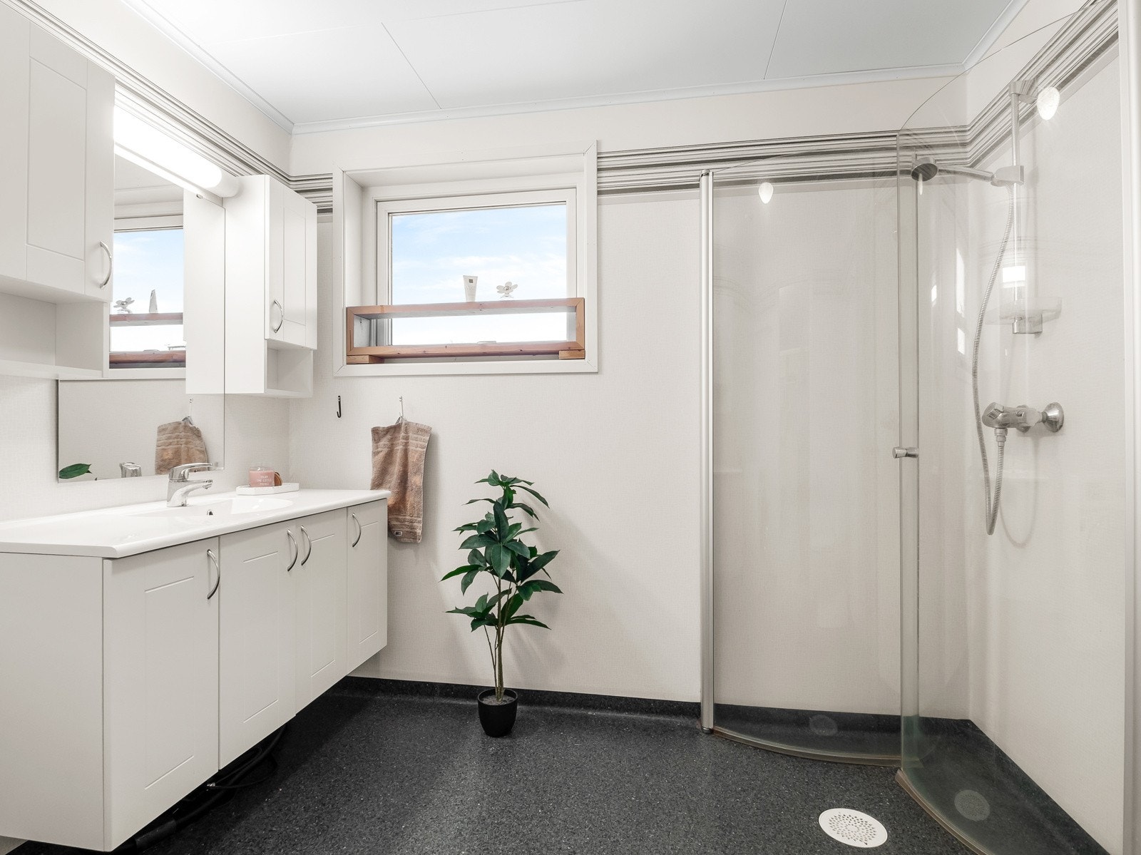 Baderommet er romslig, og har praktisk dusjhjørne med innfellbare dører Galleribilde