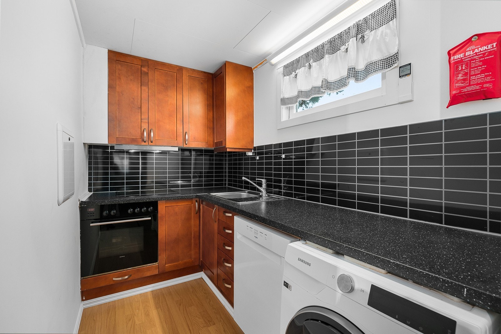 Kjøkken med opplegg for vaskemaskin og oppvaskmaskin. Det er integrert stekeovn og platetopp. Galleribilde