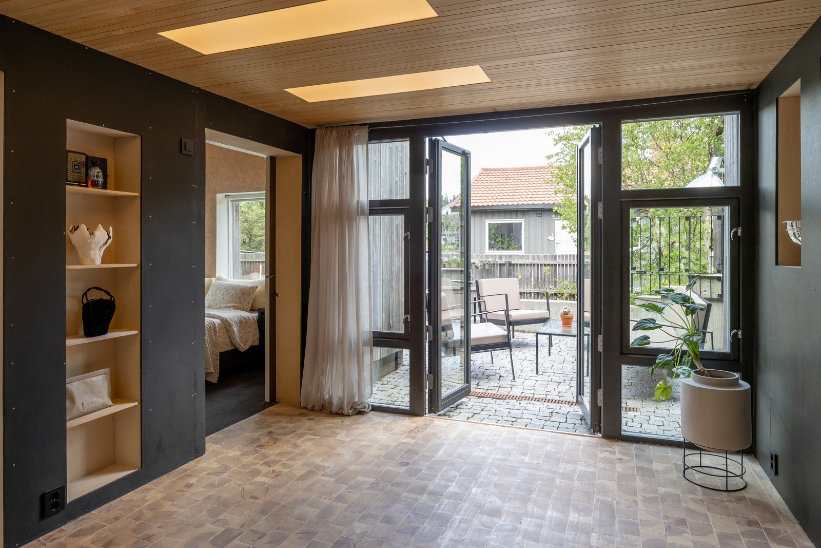 Mellomstua har utgang til ettermiddagsplassen. Integrert belysning med bruk av spiler i tak, i tillegg har man smart oppbevaring i integrerte skap. Galleribilde