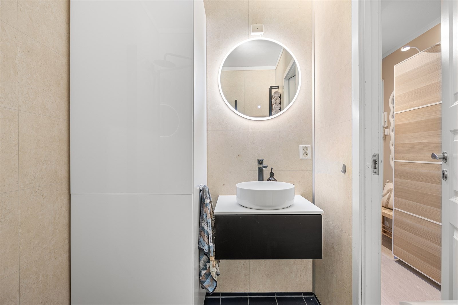 Baderommet har behagelig varme i gulv, og er utstyrt med dusjhjørne, opplegg for vaskemaskin, og servant. Selger har satt inn et høyskap for å maksimere lagringsplass for baderomsartikler. Galleribilde