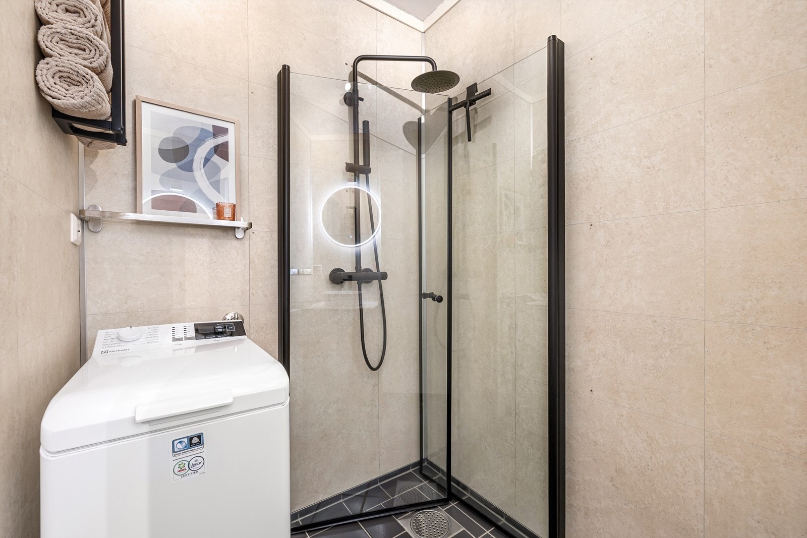 Rommet for velvære har flislagt gulv og baderomsplater på veggene, samt opplegg for vaskemaskin. I følge nåværende eier er det også plass for en større vaskemaskin. Galleribilde