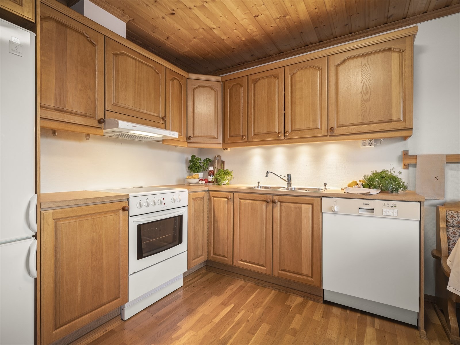 Det er god skap- og benkeplass på kjøkken i robust tre. Galleribilde