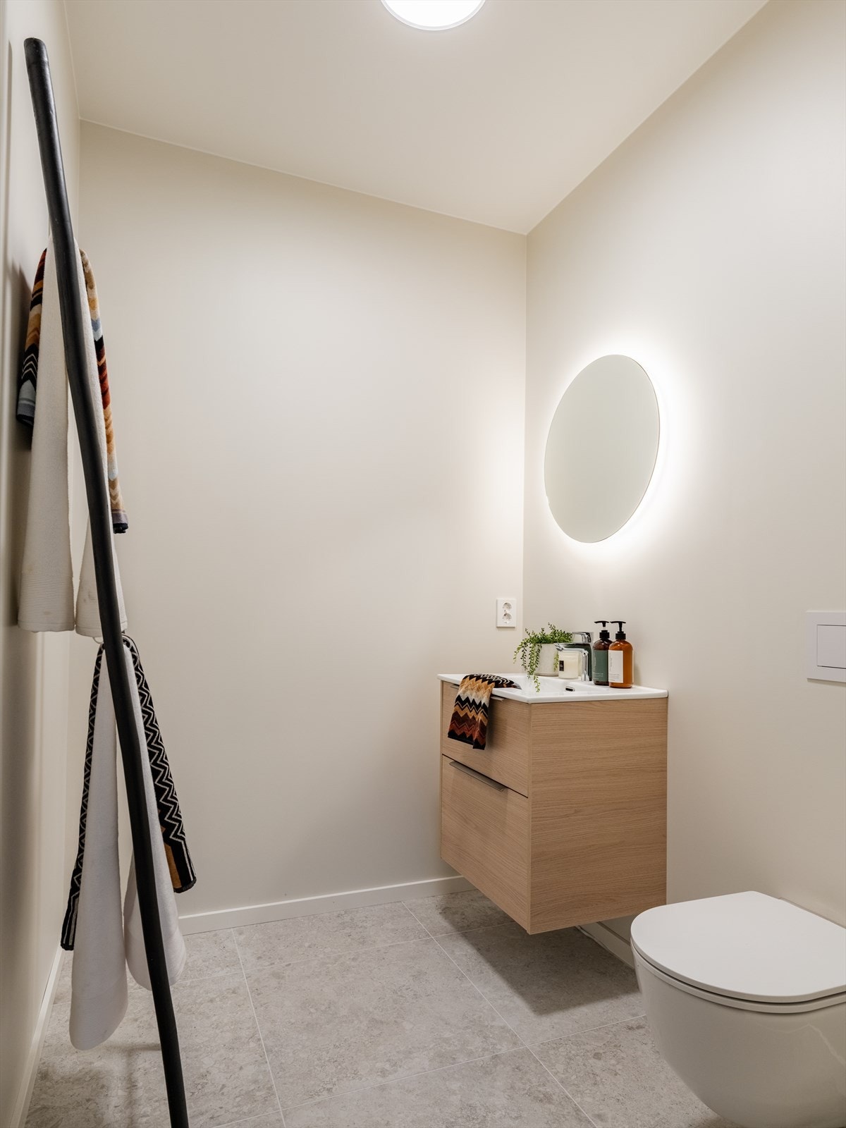 I boligens 1. etasje er det et separat toalettrom, godt egnet for gjester. Rommet har flislagt gulv med vannbåren gulvvarme. Speil med integrert belysning og vegghengt toalett. Galleribilde