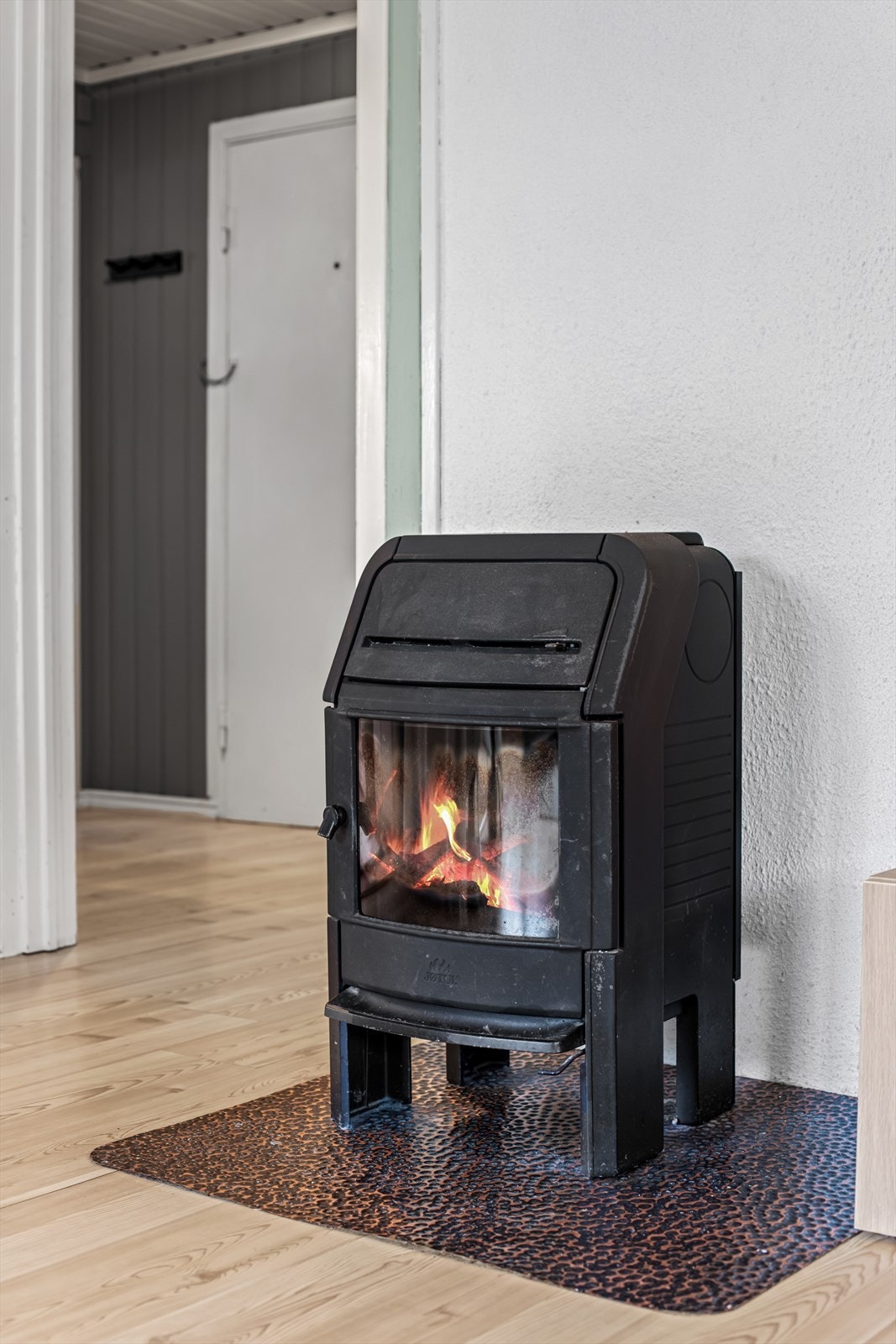 Oppholdsrommet er utstyrt med en koselig peisovn som sørger for ekstra varme og hygge på kalde dager. Galleribilde