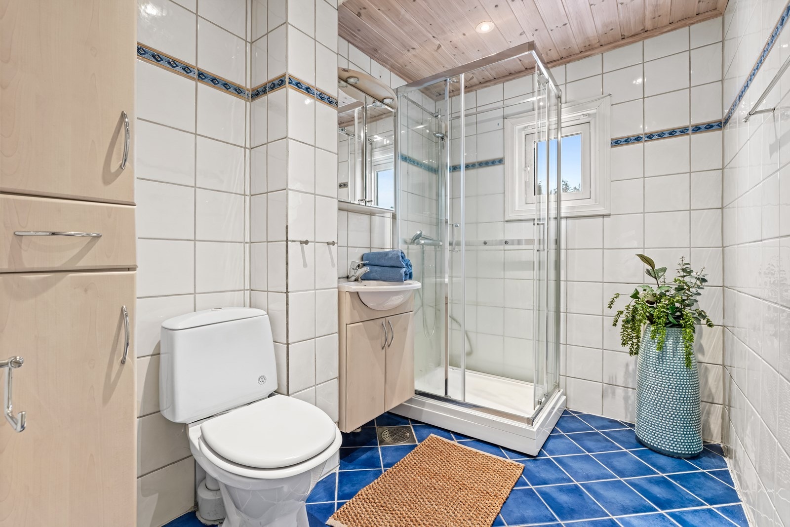 Eldre, flislagt baderom med downlights og naturlig lys inn fra vindu. Det er et felles vaskerom i kjeller hvor denne andelen har plass til egen vaskemaskin. Vaskerommet deles med naboen i 1. etasje. Galleribilde