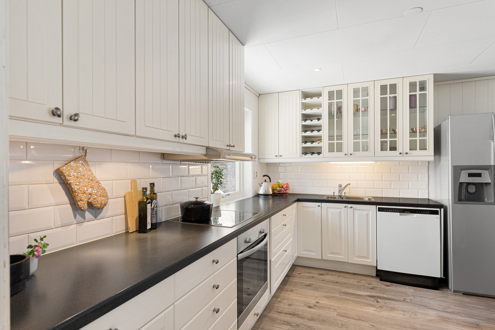 Kjøkkenet fra 2008 har profilerte fronter, laminatbenkeplate og integrert stekeovn og platetopp. Galleribilde