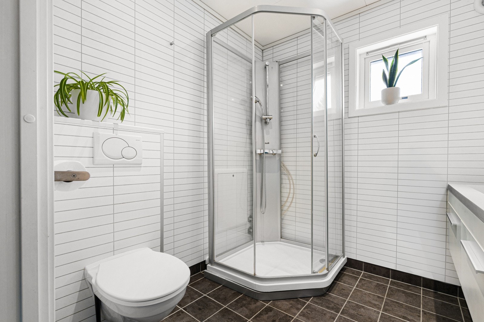 Badet er utstyrt med dusjhjørne og har baderomsplater på veggene for enkelt vedlikehold. Spotter i himlingen gir god og jevn belysning på badet. Galleribilde