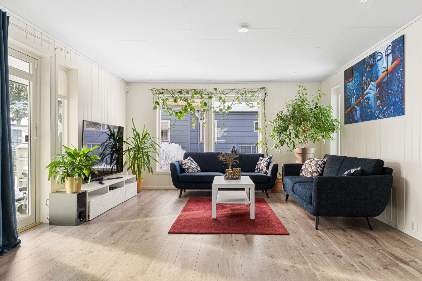 Store vindusflater gir rikelig med naturlig lys inn i stuen. Galleribilde