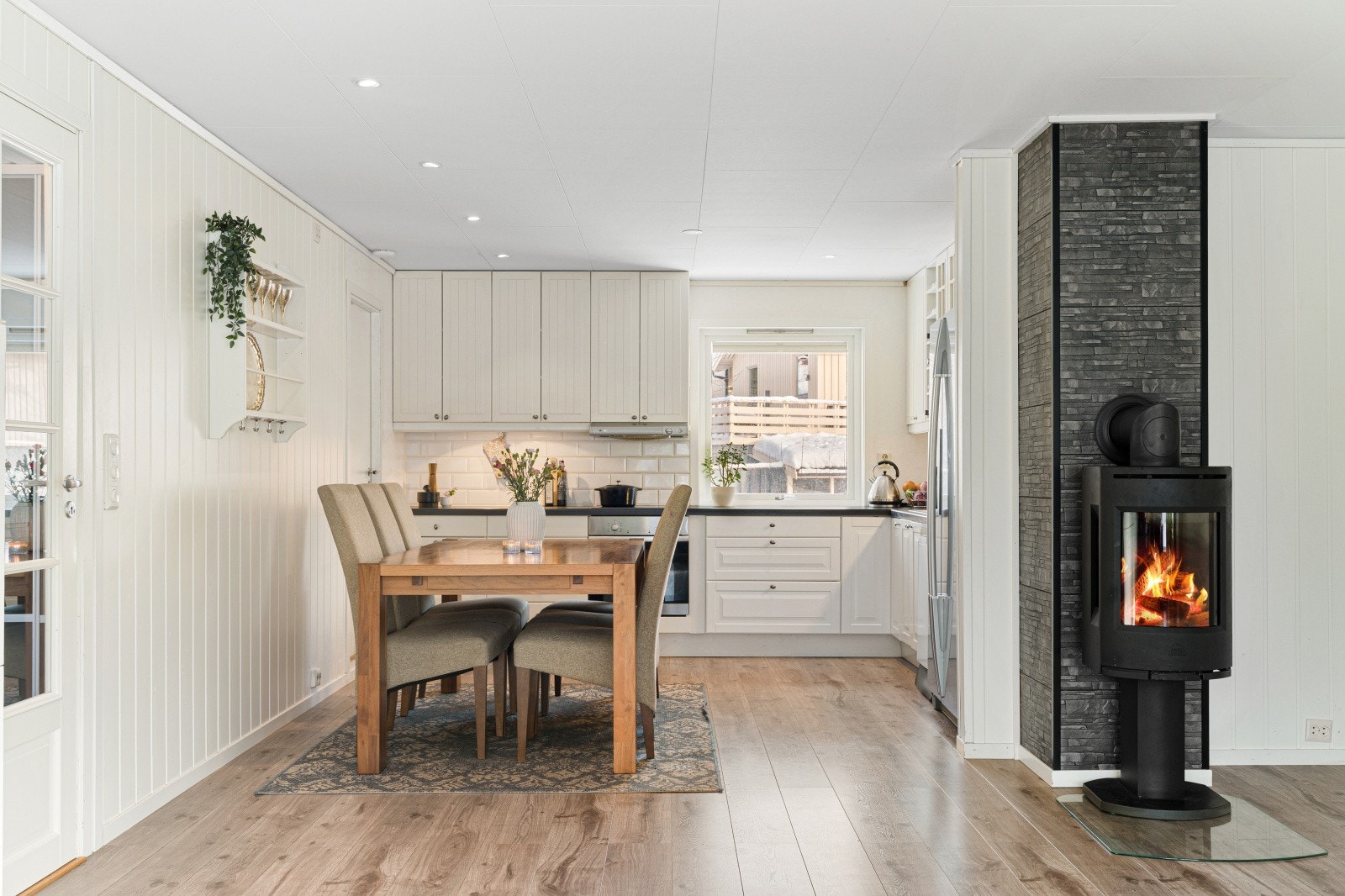 Vedovnen fra 2018 er et sentralt og hyggelig element mellom spisestuen og kjøkkenet. Galleribilde