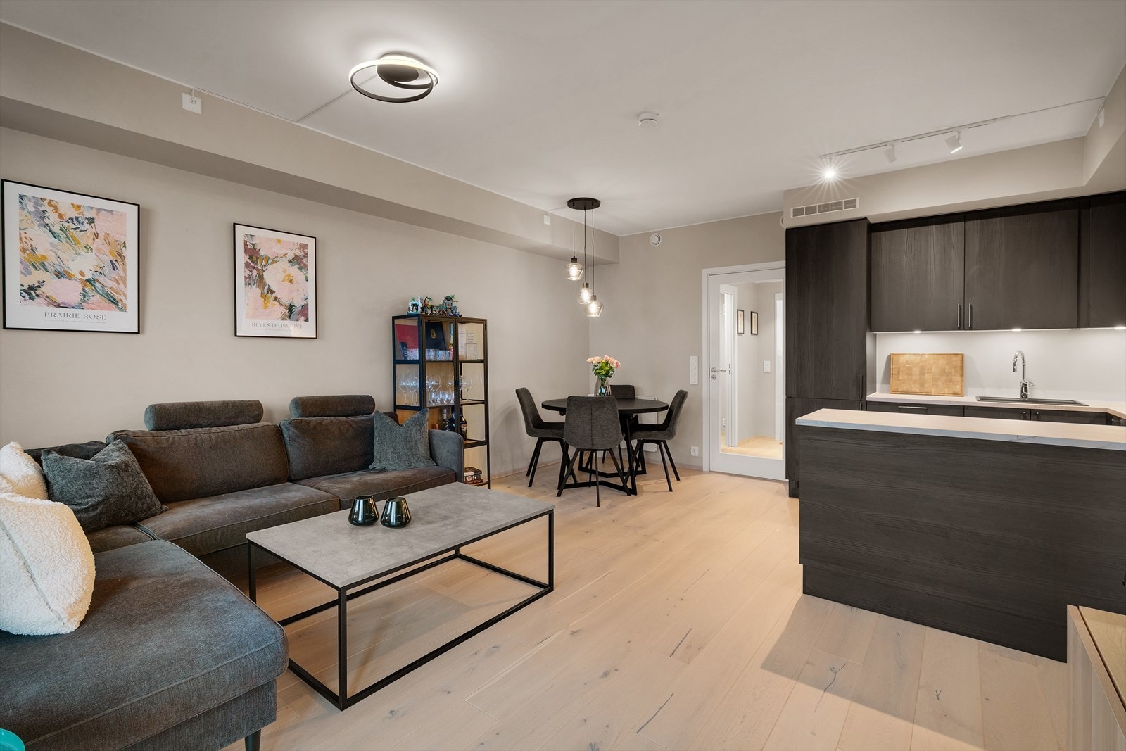 Stue og kjøkken er samlet i en åpen løsning som legger til rette for hyggelige sammenkomster, med rom for både romslig sofagruppe og spiseplass. Galleribilde