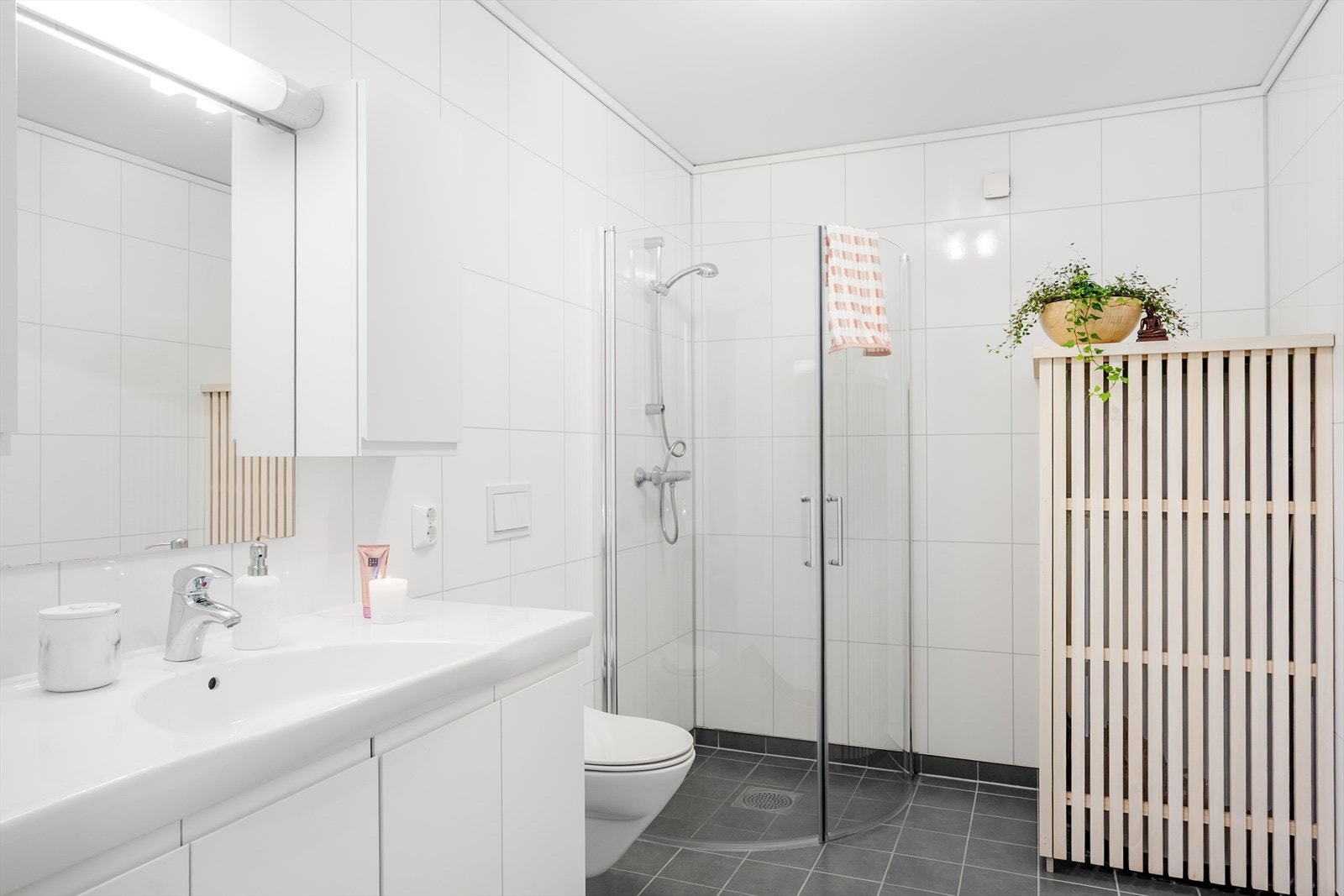 Badet inneholder innredning med servant, vegghengt toalett og dusjhjørne Galleribilde