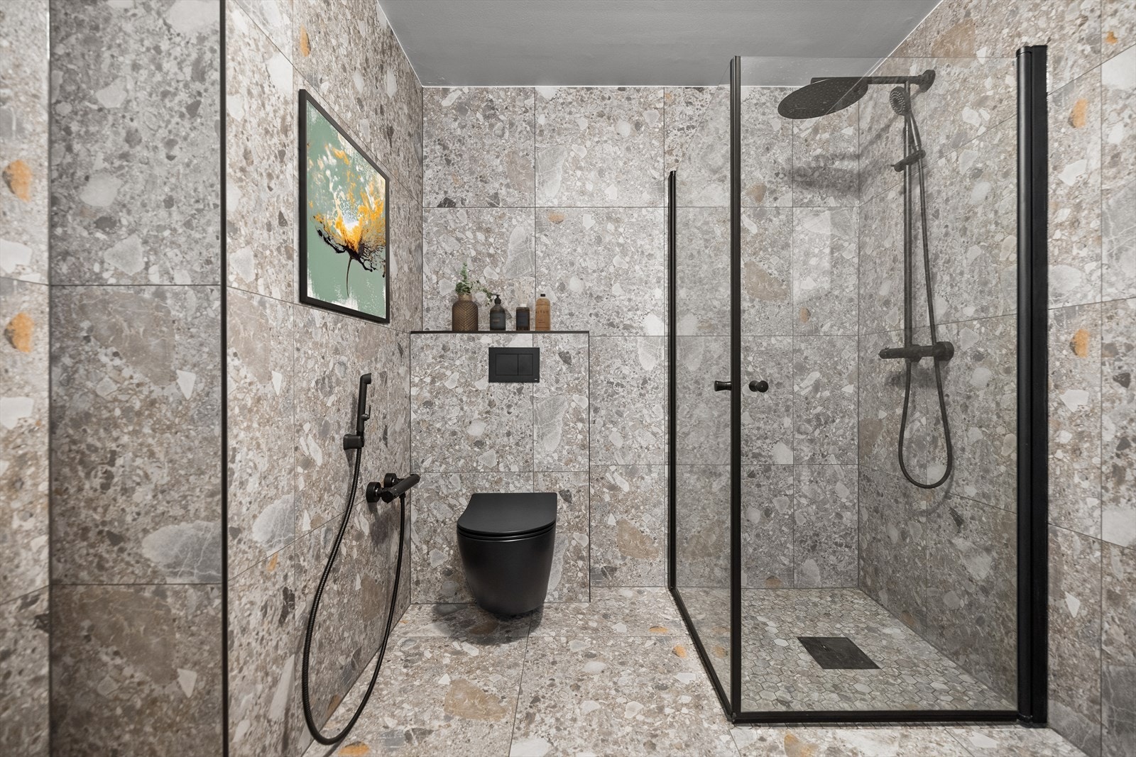 Det er flis på gulv og elektriske varmekabler. Flis på vegger og malt betong i taket. Stort dusjhjørne Galleribilde