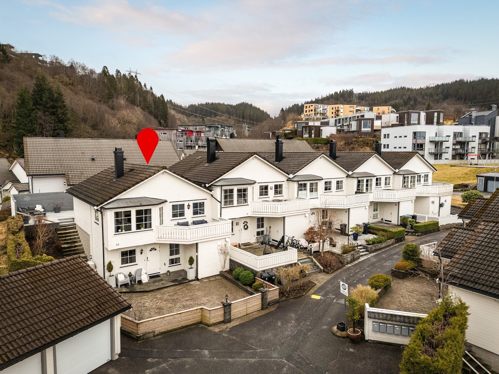 Foto: Trond Reksten. Boligen ligger på ende i en gate uten gjennomgangstrafikk. Inngjerdet hage og har flere fine uteplasser. Garasje m/elbil-lader like til venstre i bildet. Galleribilde