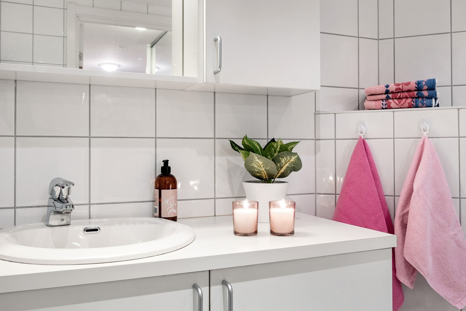 Detalj av servant med underskap, speilskap og flislagte vegger. Galleribilde