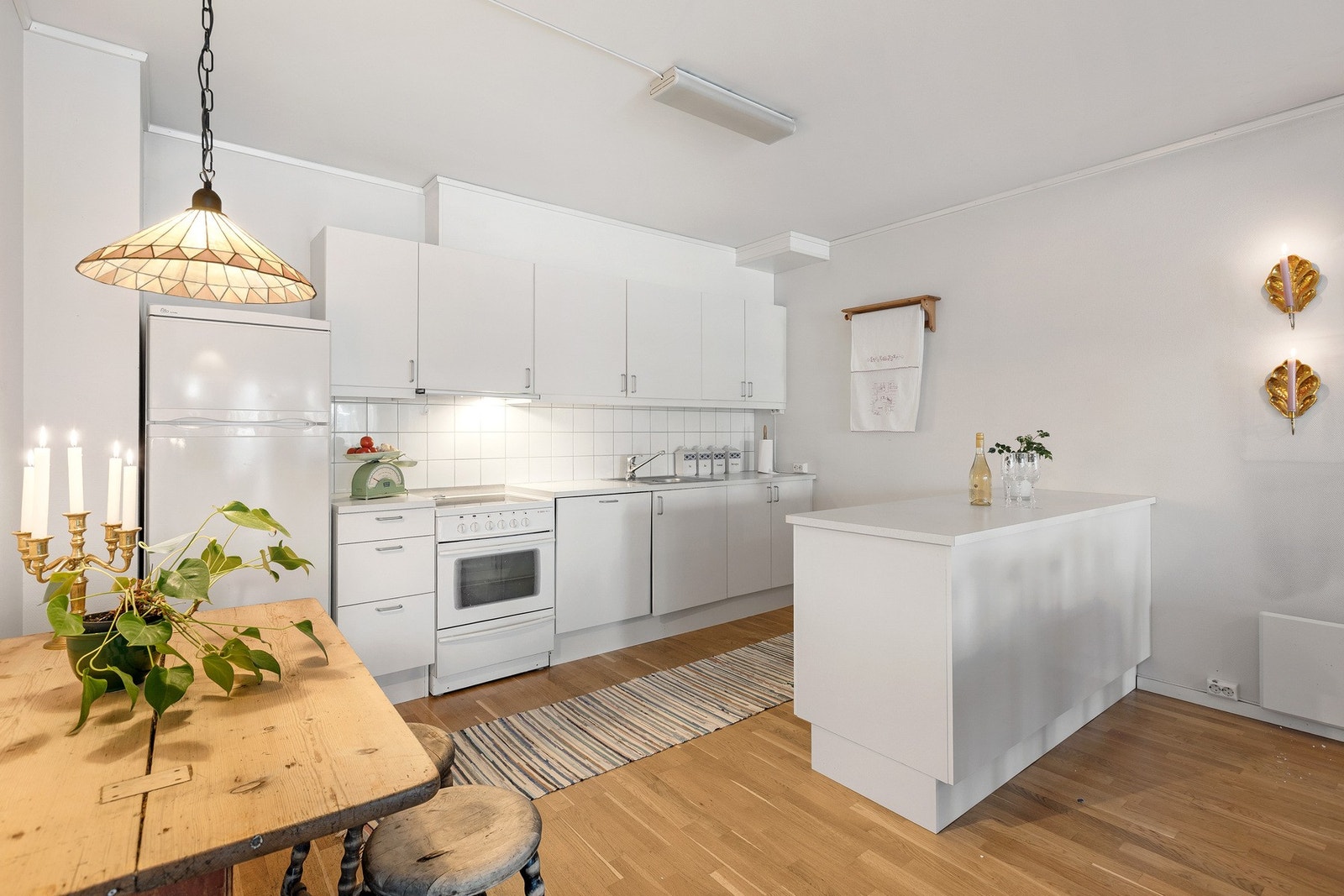 Lyst kjøkken med hvite fronter, god skapplass og praktisk planløsning. Galleribilde