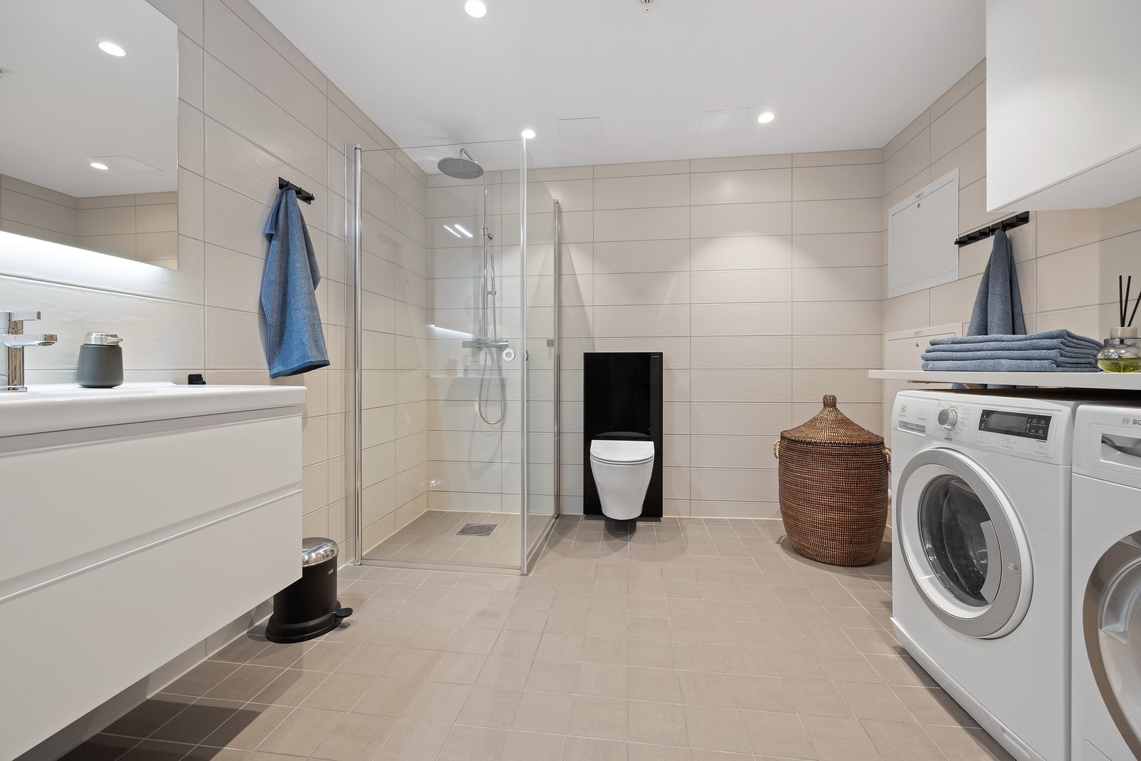 Stort delikat baderom med opplegg for vaskemaskin og tørketrommel Galleribilde