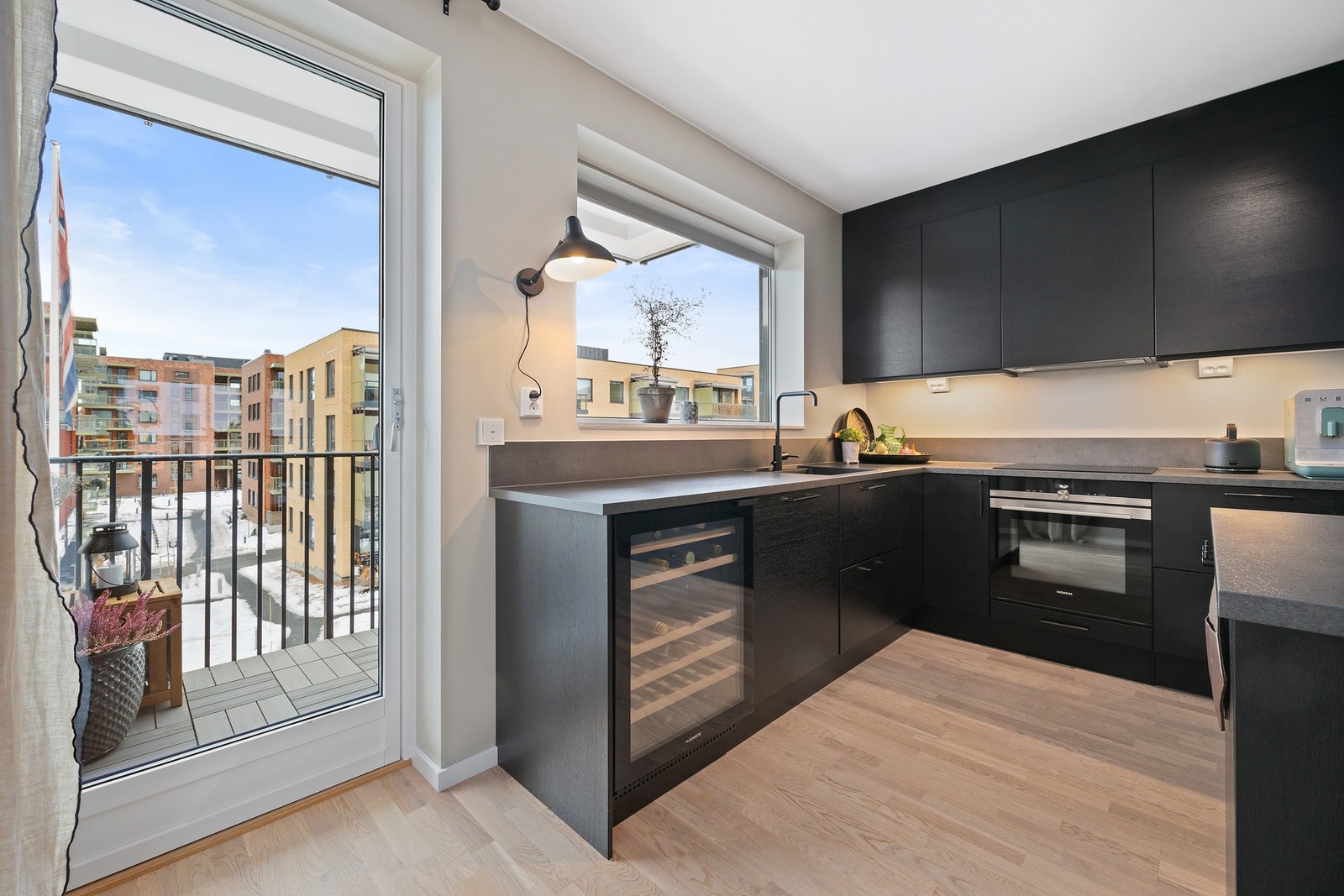 Integrerte hvitevarer som kjøl og frys i hvert sitt høyskap, oppvaskmaskin, platetopp, komfyr samt vinskap Galleribilde