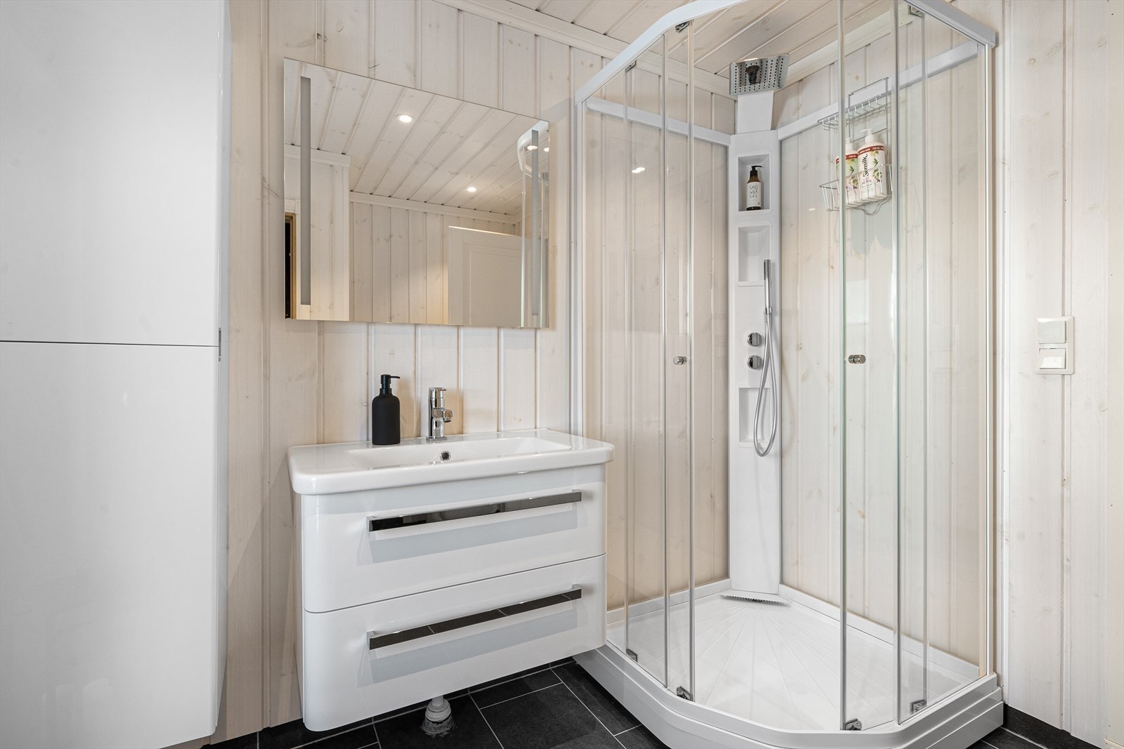 Hovedbadet inneholder toalett, dusjkabinett og servantinnredning med skuffer, skap og speil. Galleribilde