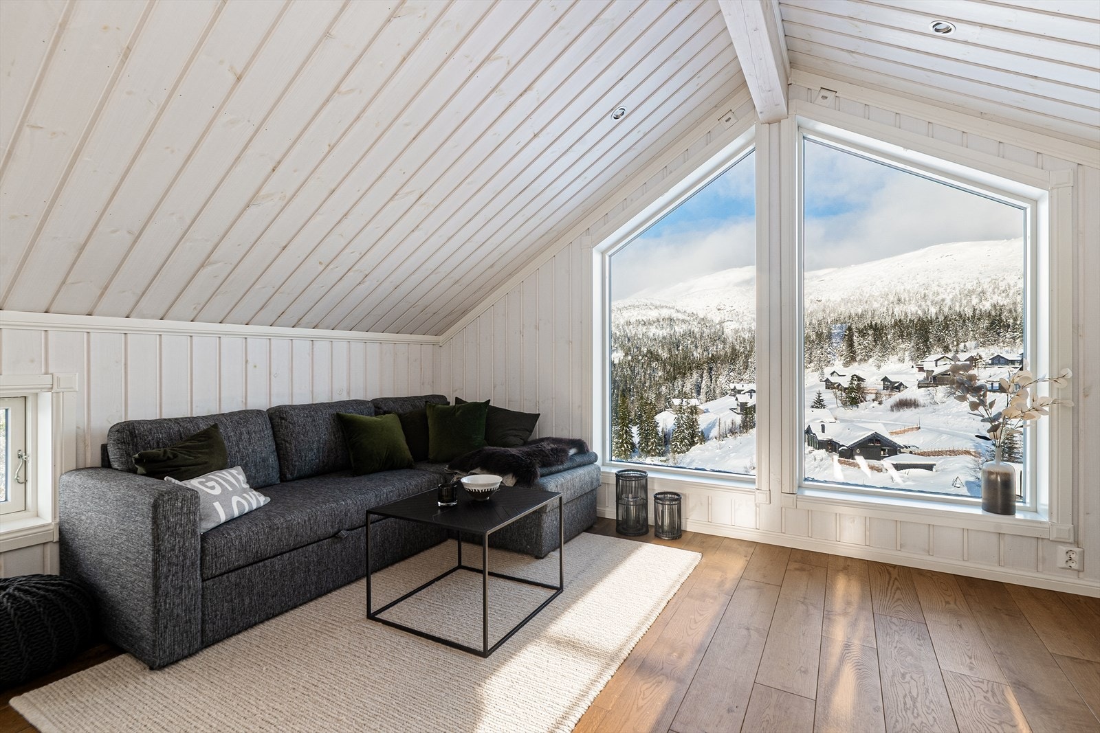 Hytta har en lys og pen loftstue med store vinduer og god plass for møblering. Galleribilde