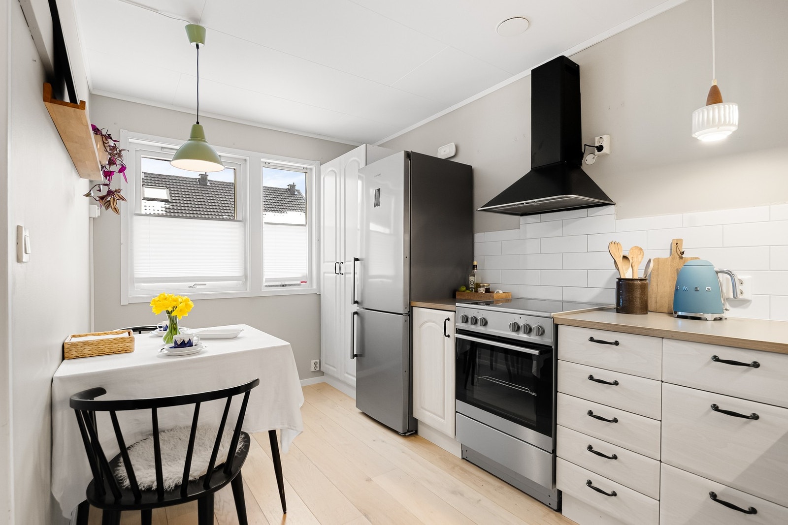 Pen kjøkkeninnredning med profilerte fronter i foliert utførelse og laminerte benkeplater med nedfelt oppvaskkum. Galleribilde