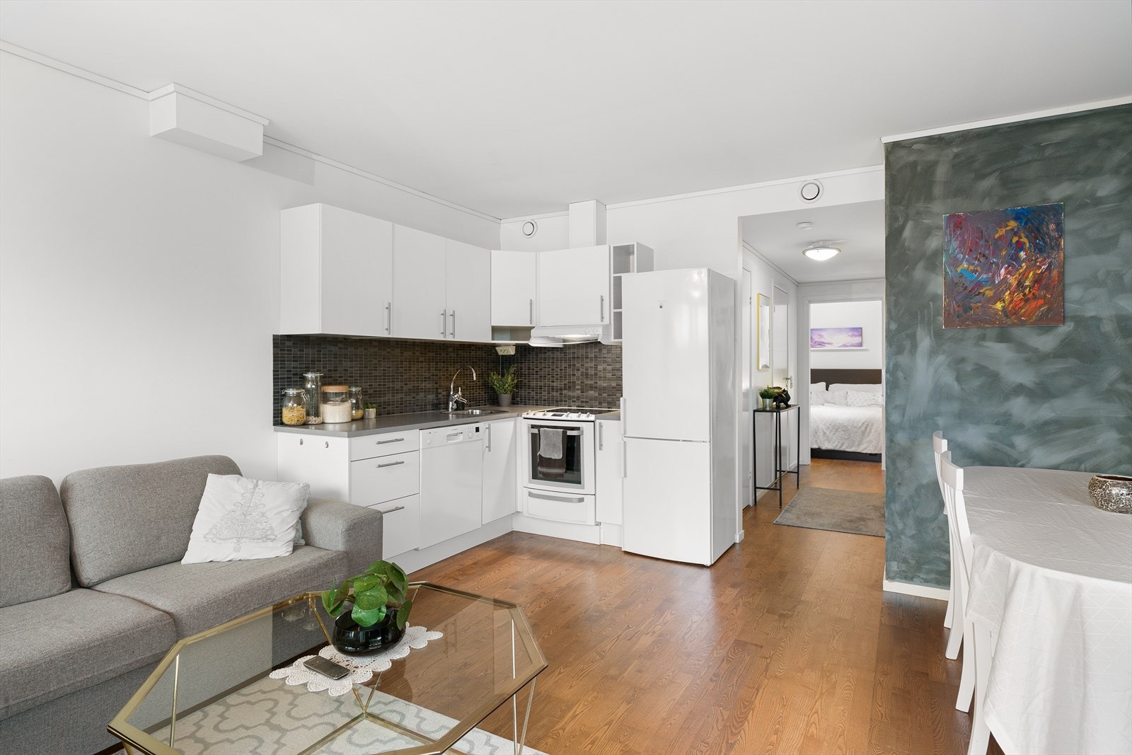 Stue og kjøkken i åpen løsning med plass til både sofa og spisebord. Galleribilde