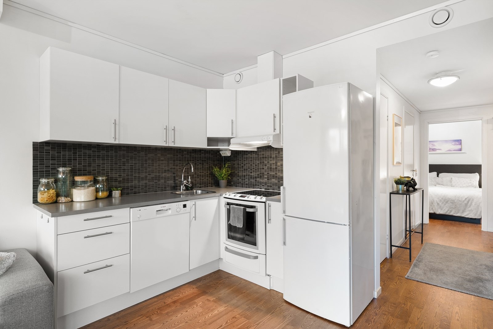 Kjøkken med god skapplass. Fliser og belysning over benk. Hvitevarer medfølger i handelen. Galleribilde