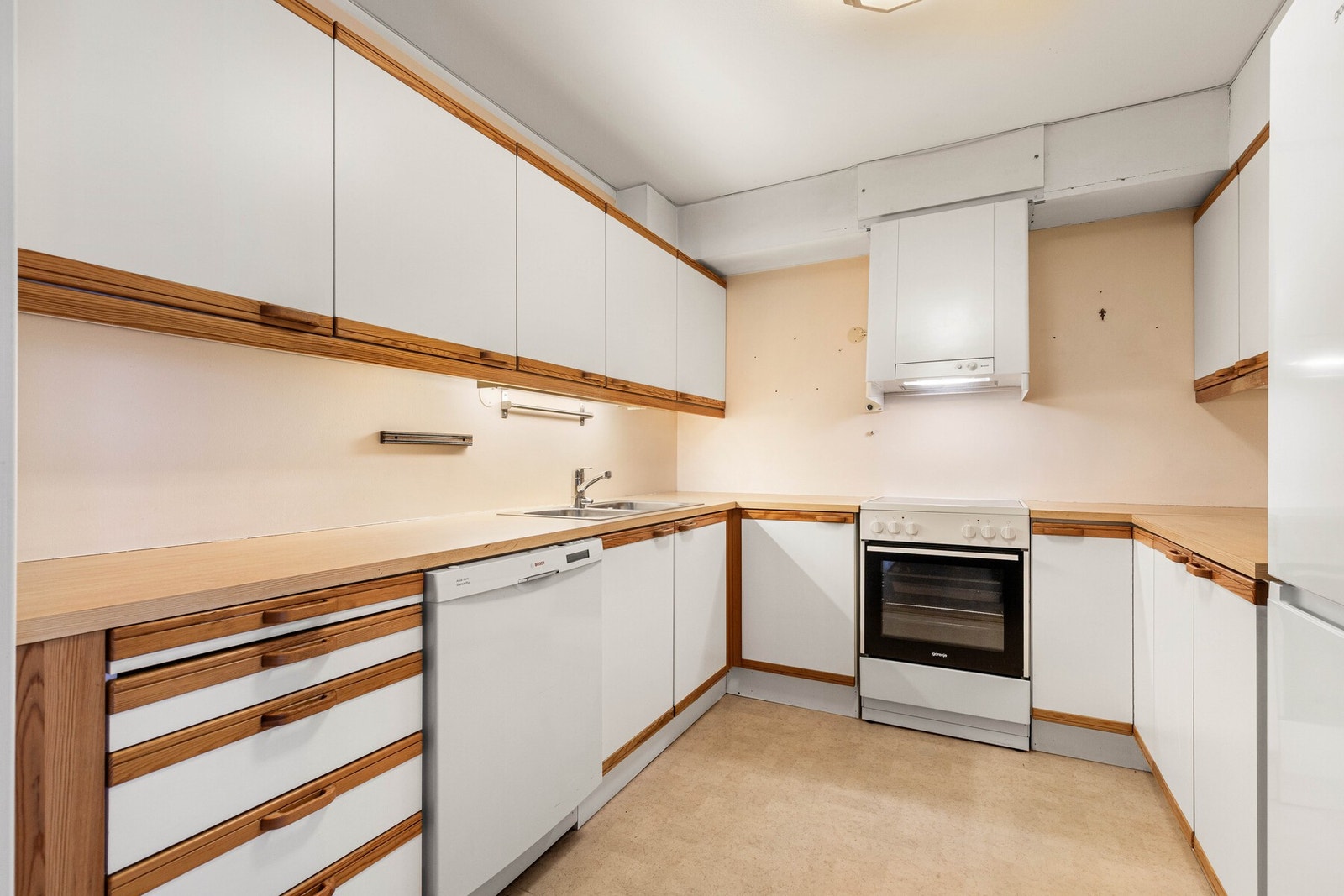 Tilbaketrukket i en eget rom har leiligheten et funksjonelt kjøkken i hesteskoform. Galleribilde