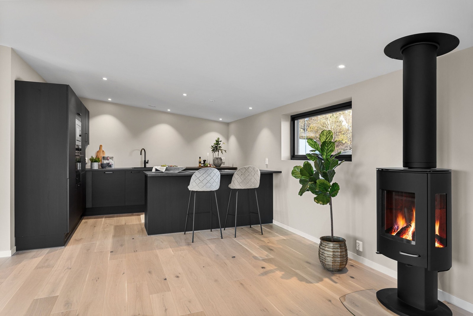 Delikat og moderne kjøkken fra JKE Design, modell Nordic Silk Ask Sort matt, med slette, sorte fronter og stilren laminatbenkeplate. Galleribilde