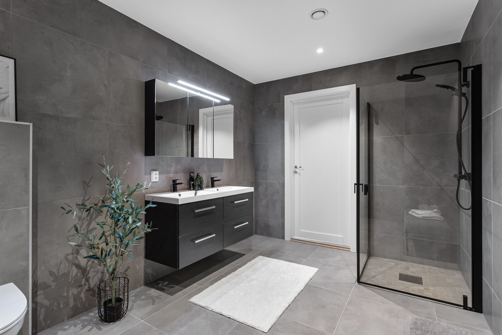 Stilrent bad med tidsriktige 60×60 fliser, varmekabler og downlights som gir et moderne preg. Galleribilde