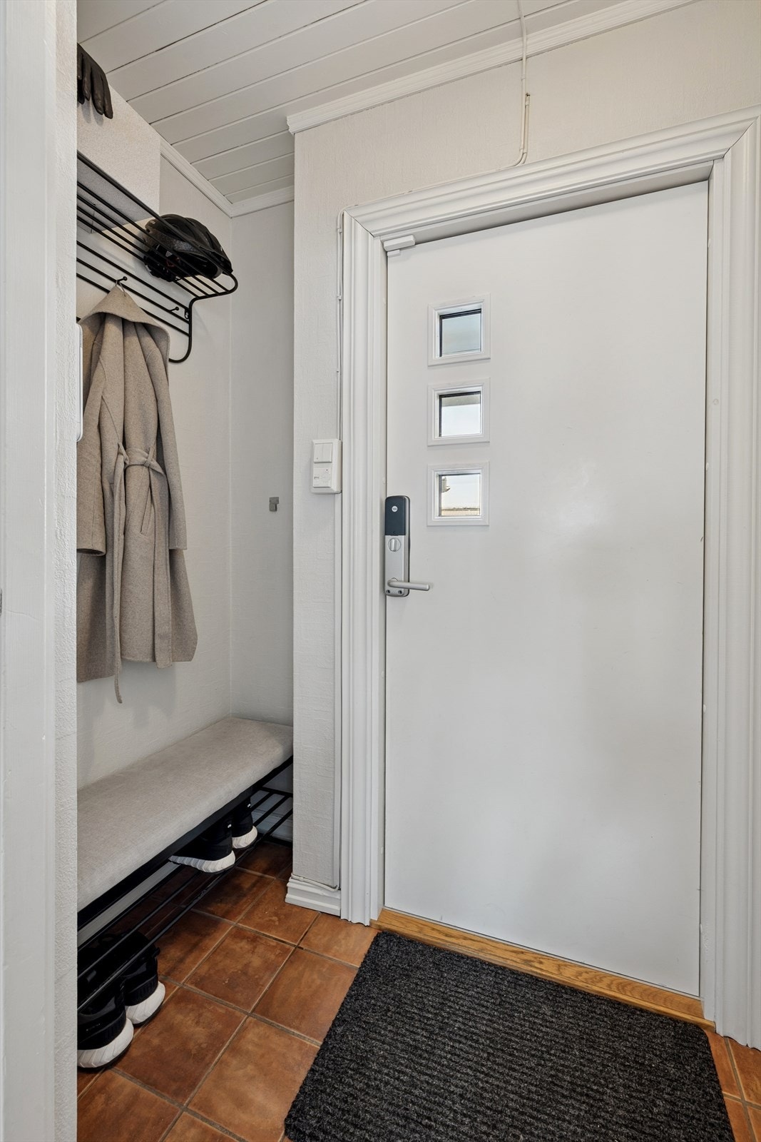 Vindfang med flislagt gulv med gulvvarme, og plass til oppbevaring. Galleribilde