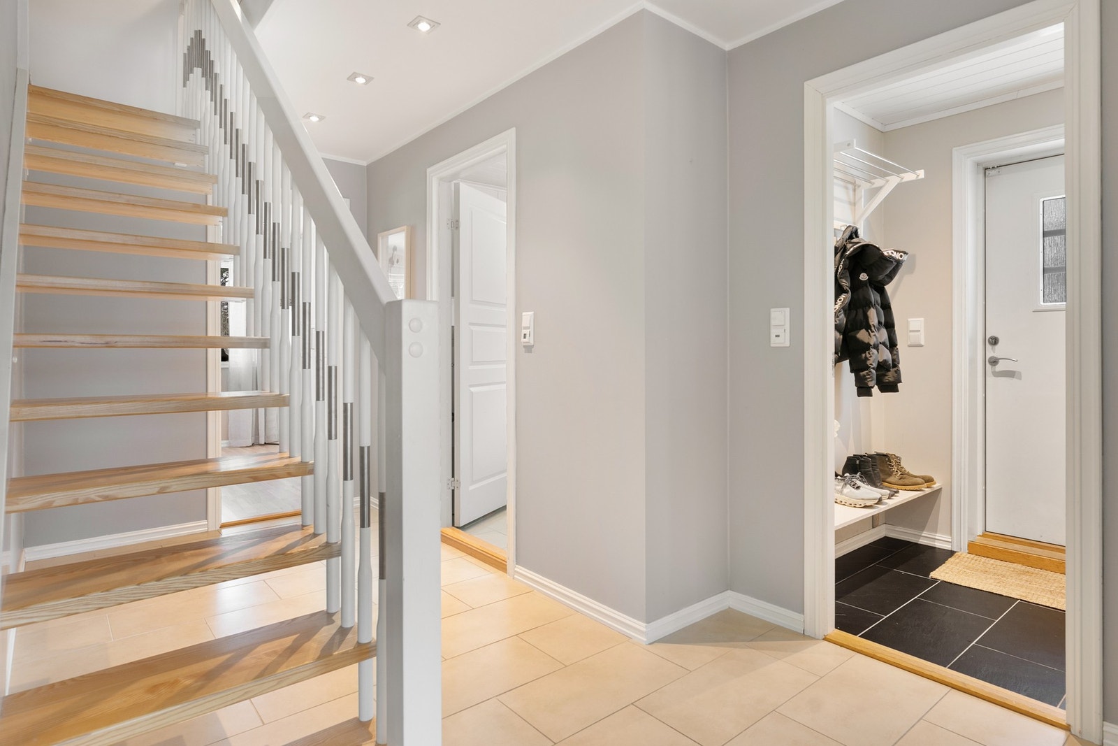 Entre med fliser på gulv med gulvvarme og lysmalte vegger. Galleribilde