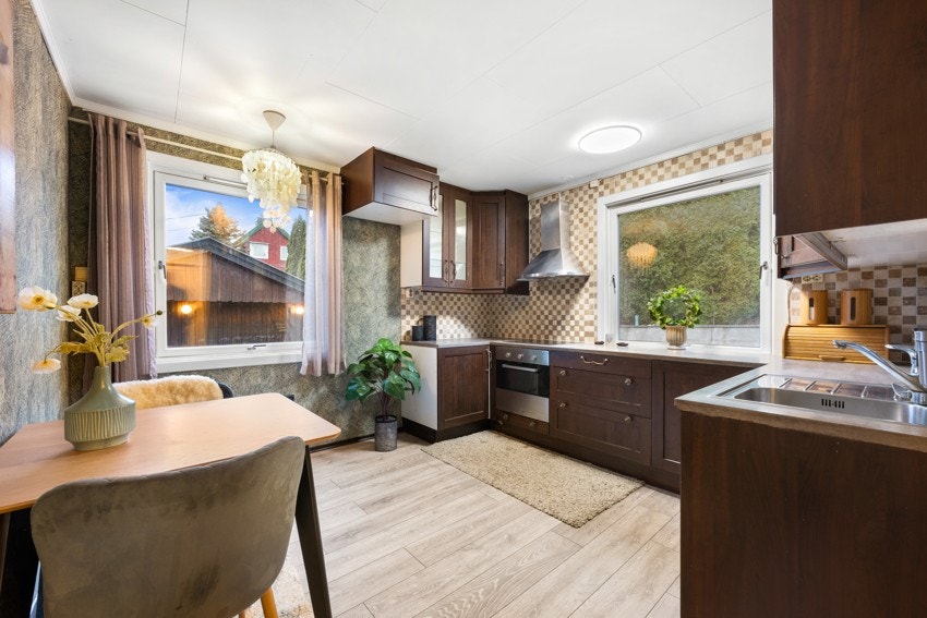 Kjøkkenet har innredning med mørke slette fronter og benkeplate i laminat Galleribilde