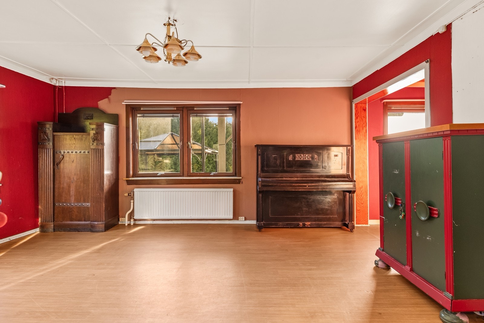 Romslig stue i første etasje med sollys inn fra flere retninger Galleribilde