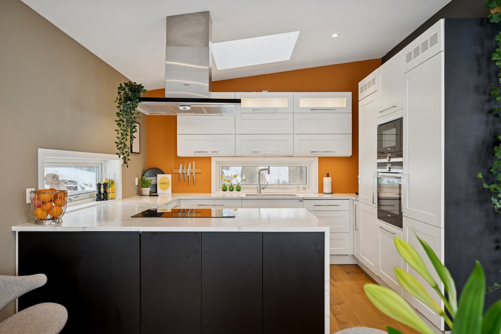 Kjøkkenet er levert av Huseby og fremstår solid og funksjonelt, med profilerte rammefronter og benkeplate i komposittstein. Galleribilde