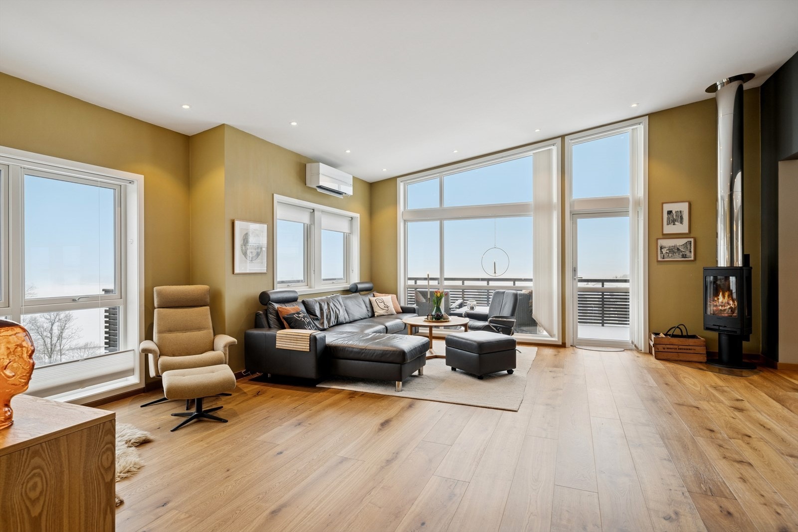 Rommet har god plass til både sofagruppe og spisebord, og en vedovn gir ekstra komfort og lun stemning i vinterhalvåret. Galleribilde