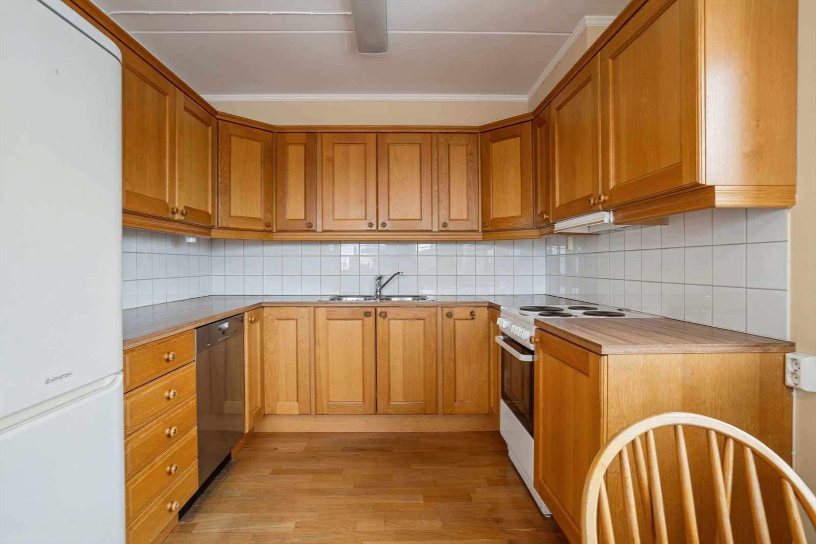 Kjøkken som har godt med skap- og benkeplass. Fliser på vegg over kjøkkenbenk. Galleribilde