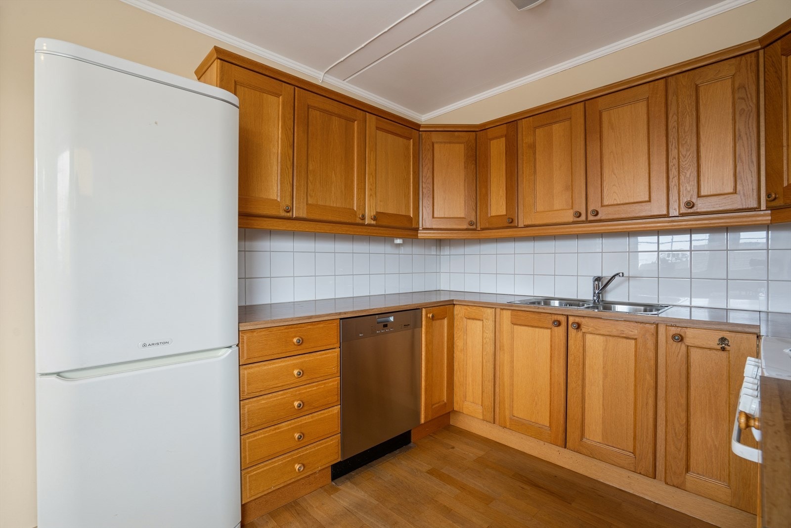 Kjøkkeninnredning i eik utførelse med en laminatbenkeplate som har et nedfelt benkebeslag med to kummer. Galleribilde