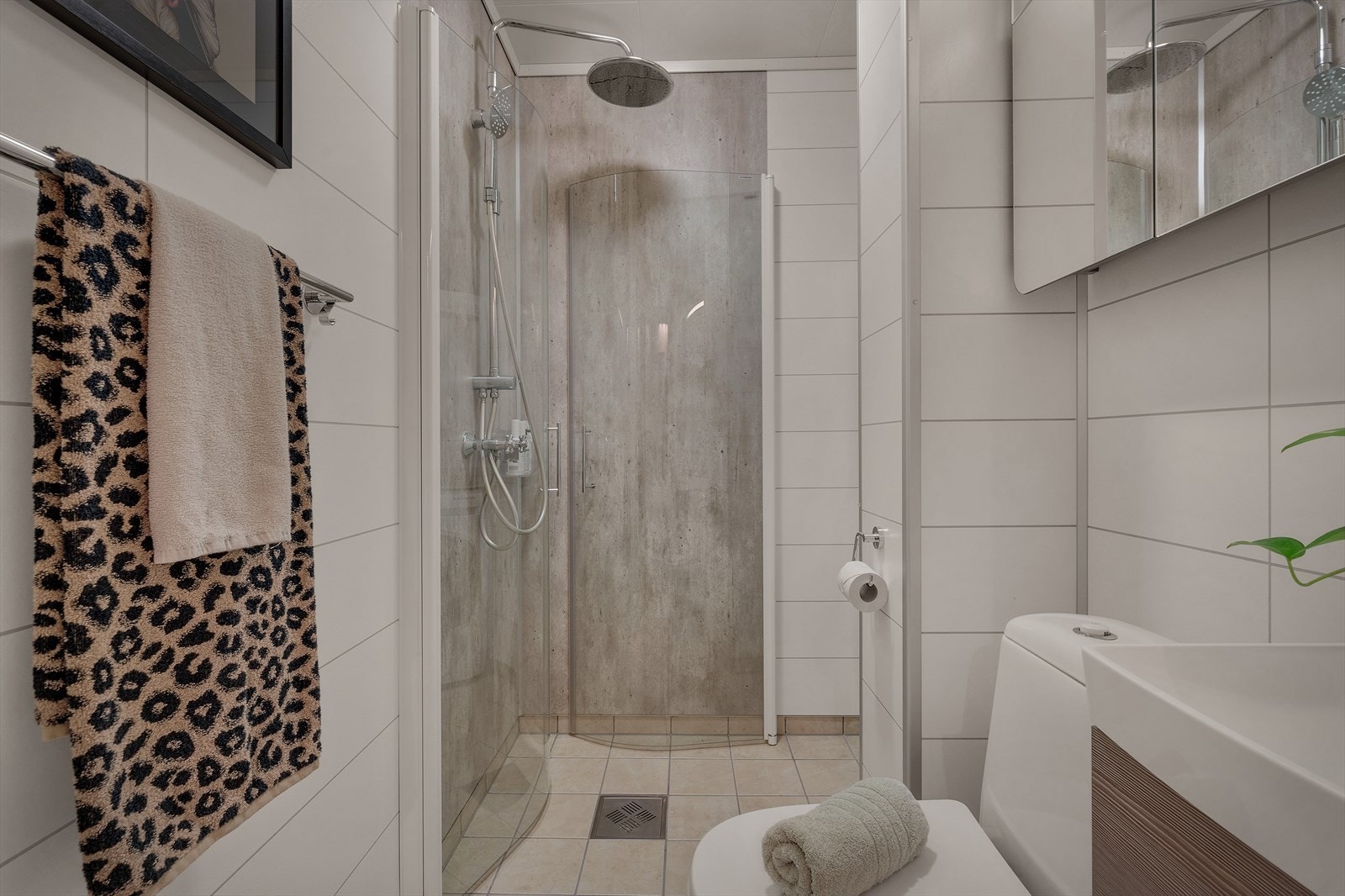 Badet har varmekabler i gulvet, flis på gulvet og baderomsplater på vegger og tak. Galleribilde