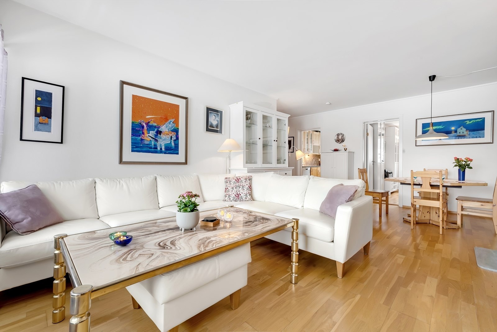 Stuen er et sosialt og lyst rom med eikeparkett på gulvet, vedovn og god plass til sofagruppe og spisegruppe. Galleribilde