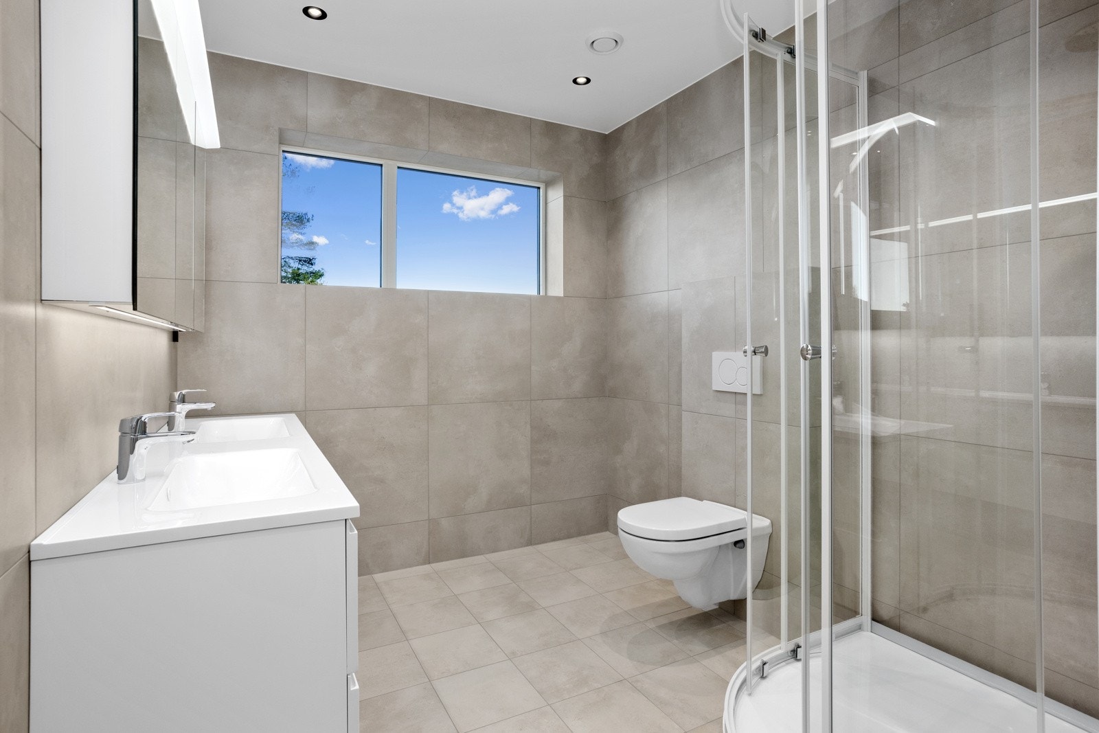 Stort flislagt bad/wc med storformatfliser (60 x 60 cm) i hovedetasje | downlights Galleribilde