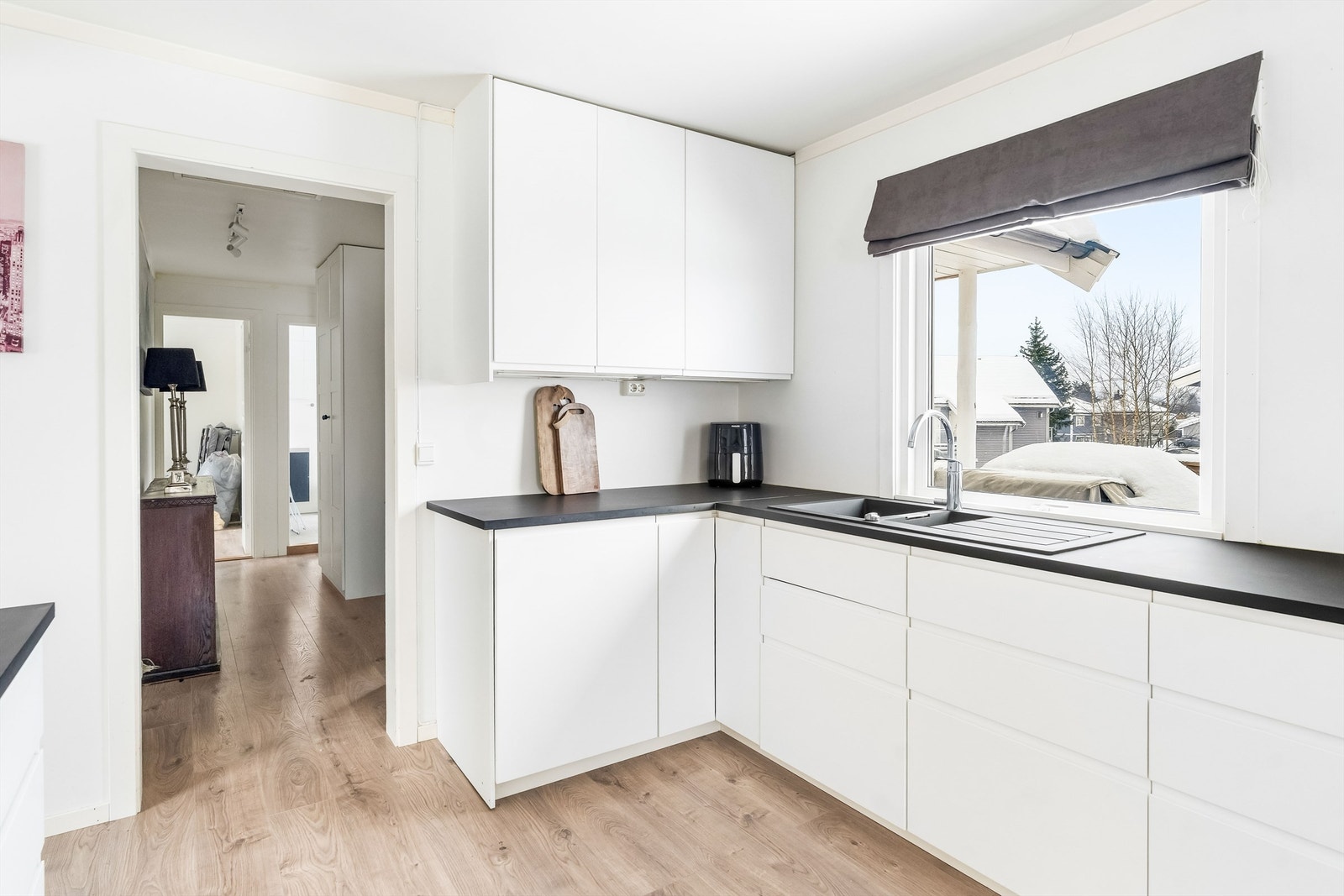 Det er godt med benkeplass på kjøkkenet, og det er et hyggelig utsyn mot nabolaget. Galleribilde