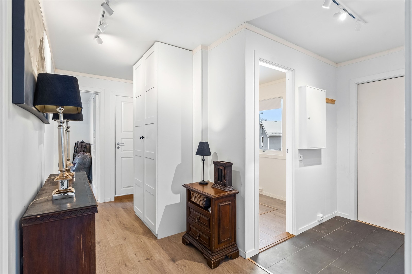 Entreen fremstår lys og tidsriktig, og det er varme i gulv i gang ved inngangsdøren. Gangen er romslig, og det er god plass til møblement og kles-hengløsninger. Galleribilde