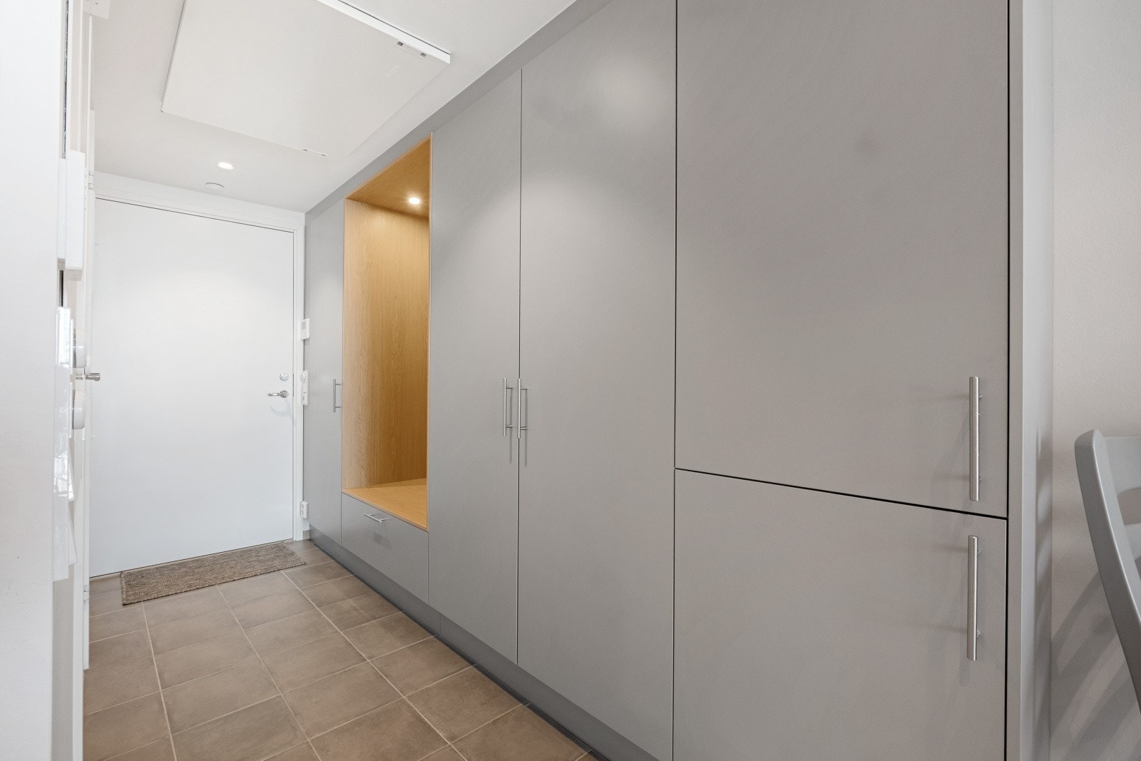 Entrè hvor garderoben byr på sittebenk med skuffe under, flere høyskap og speil Galleribilde