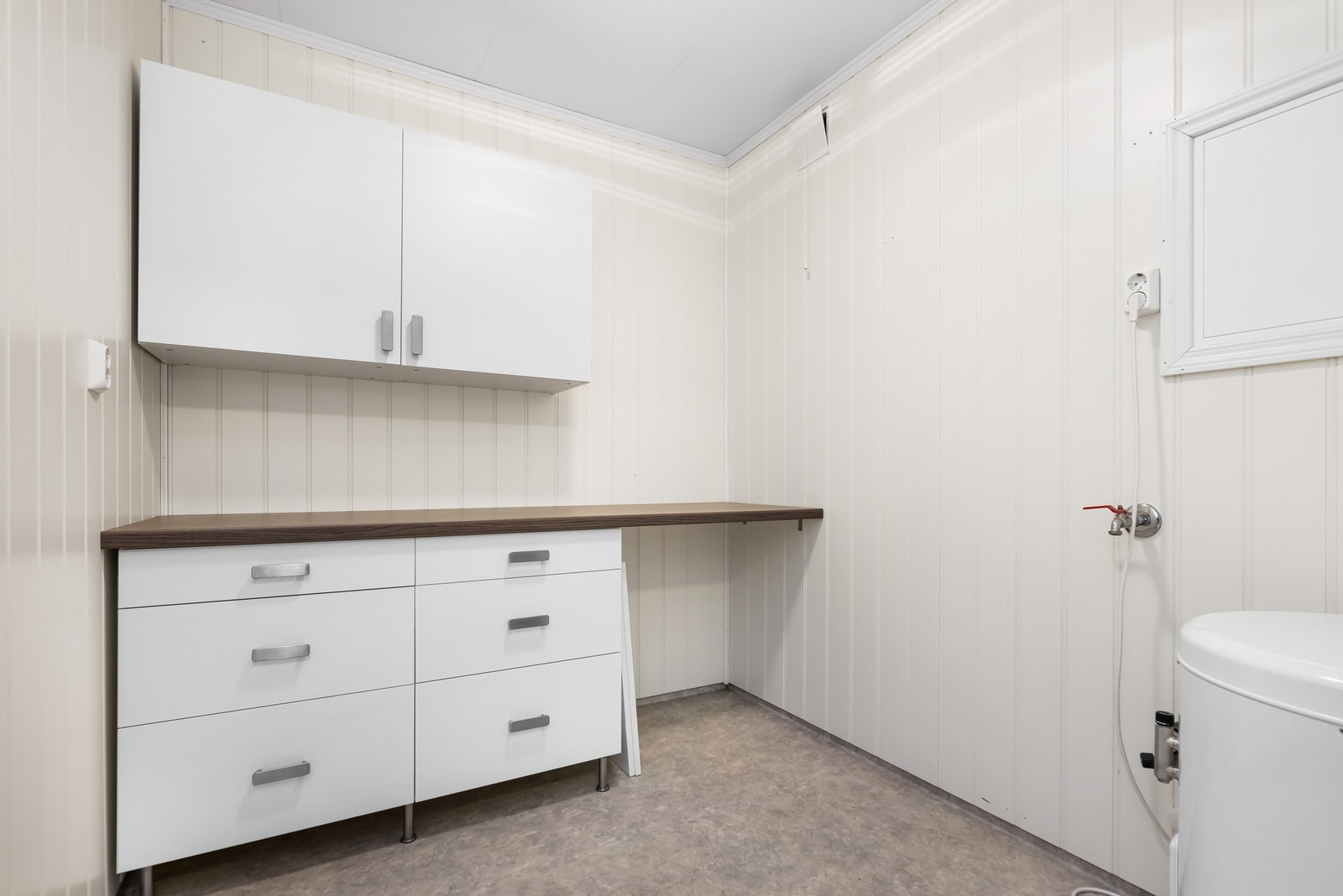 Praktisk vaskerom med opplegg for vaskemaskin/tørketrommel,
laminert benkeplate med vask/innredning/overskap. Galleribilde