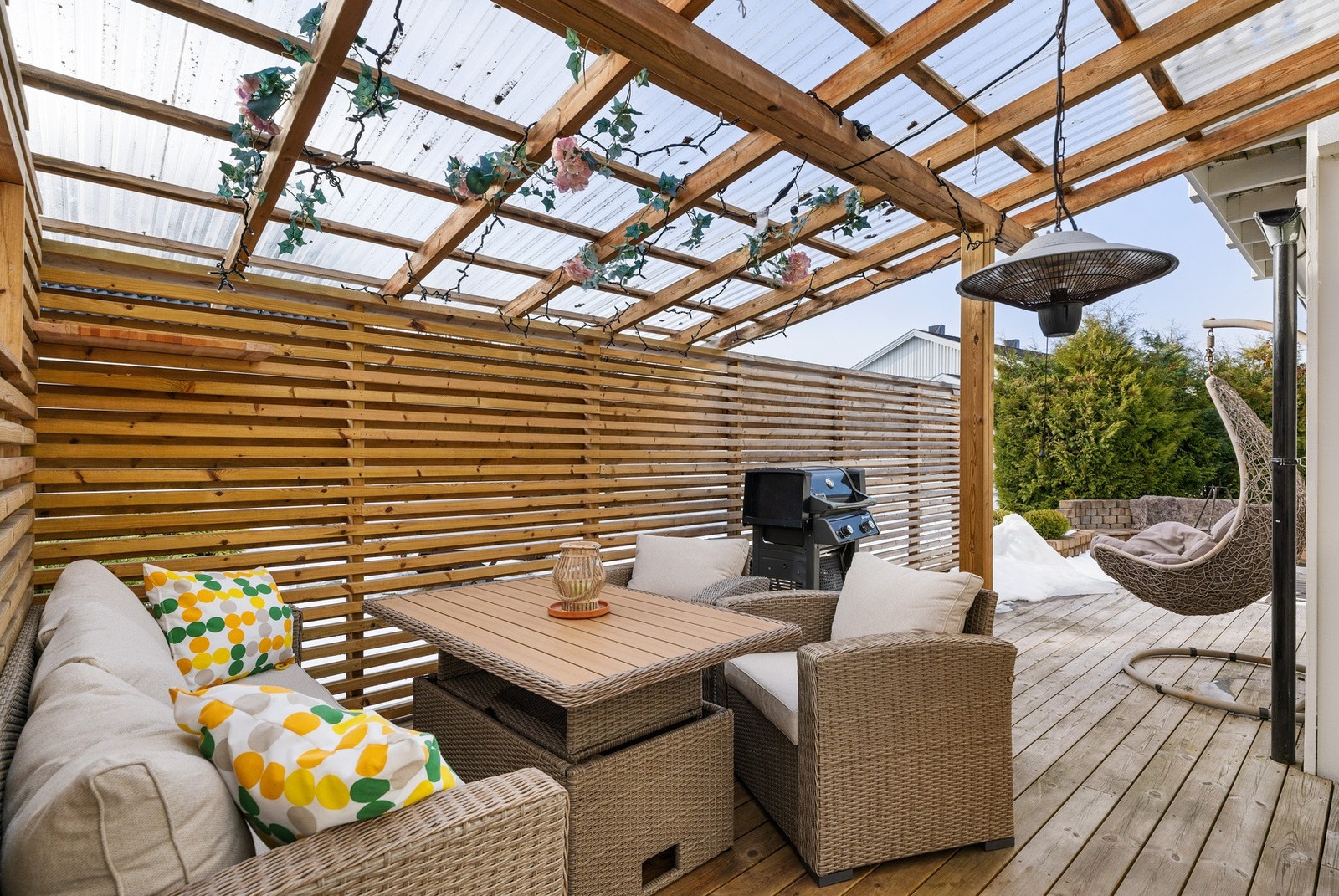 Overbygget terrasse med plass til sittegruppe og grill. Overbygg/levegg gir privatliv og ly for vær og vind. Galleribilde
