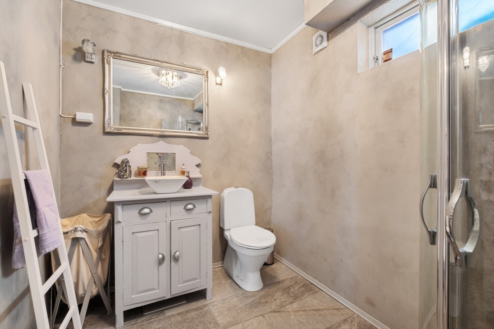 Badet er innredet med servant, toalett og dusjhjørne med faste dusjvegger. Galleribilde