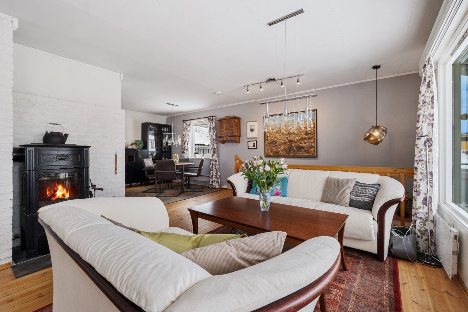 En koselig vedovn plassert ved overgangen mot spisegruppen sørger for lun og behagelig varme på kaldere dager. Galleribilde