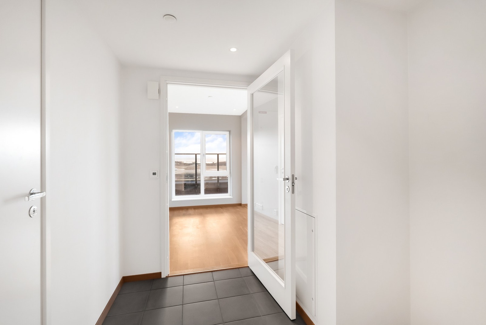 Entré med flislagt gulv og downlights i himling. Varme i gulv. Galleribilde