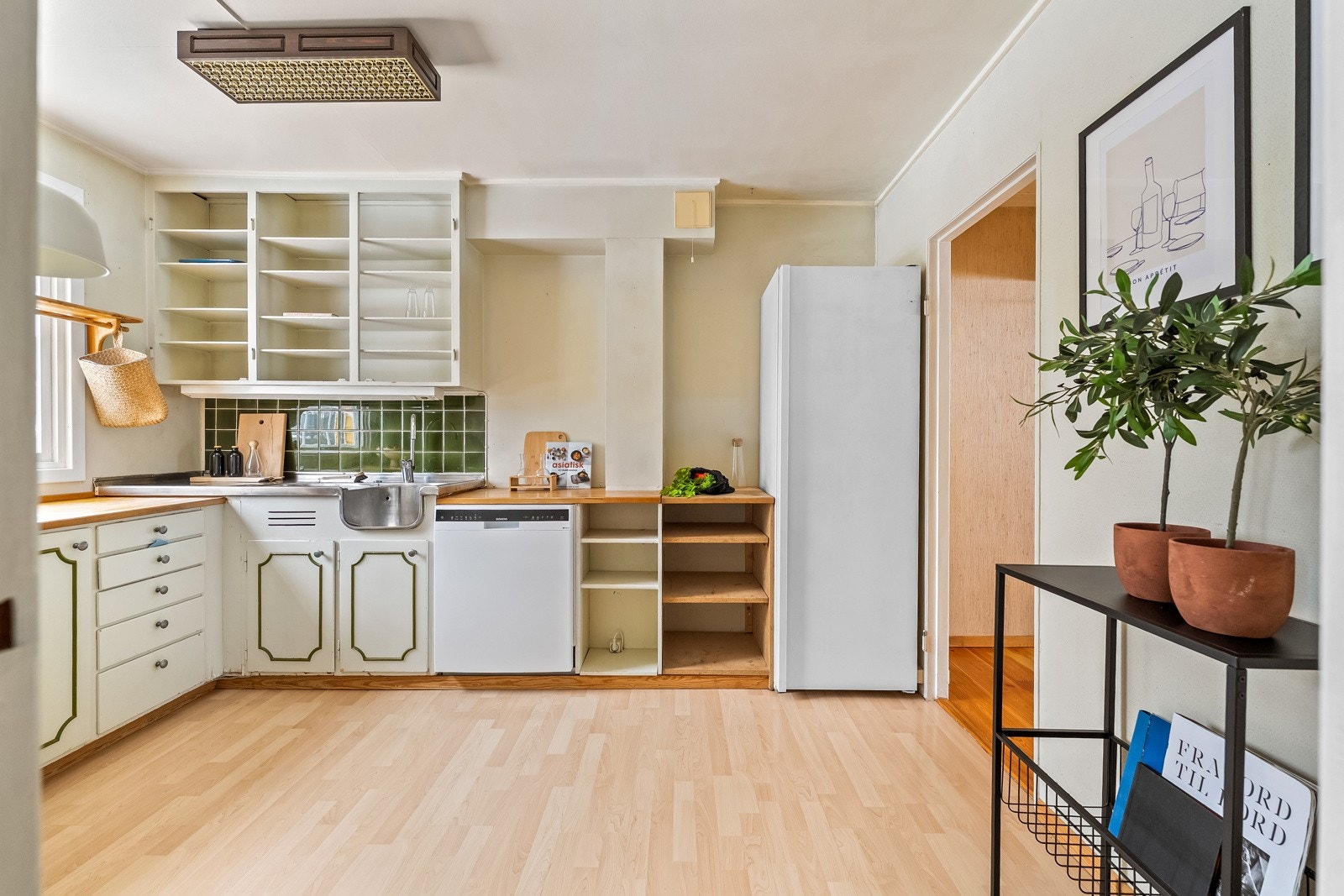 Kjøkkenet har en eldre kjøkkeninnredning med profilerte fronter og heltre benkeplate. Galleribilde